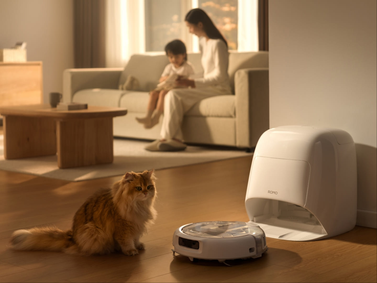 DJI Romo 2 com base branca fechada em uma sala de piso de madeira, com um gato em primeiro plano
