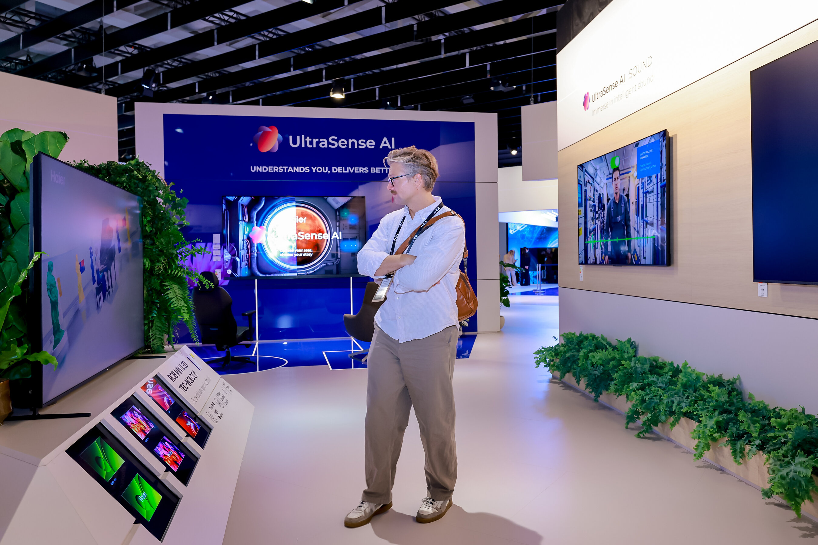 Visitante observa a área de TVs com UltraSense AI no estande da Haier na IFA 2026