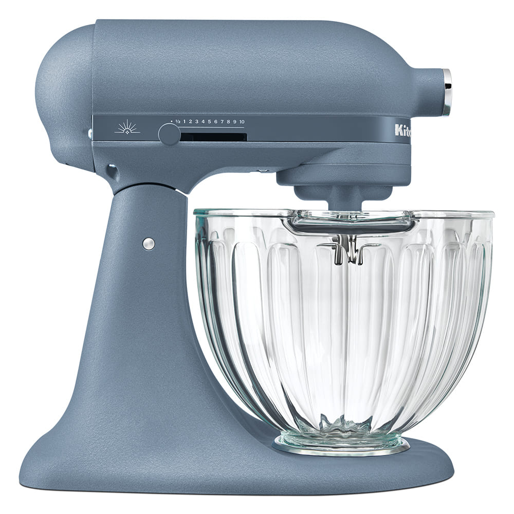Batedeira KitchenAid Luminaire vista de lado, em azul Blue Peppercorn, com a tigela de vidro canelado e o botão de luz ao lado da alavanca de velocidade