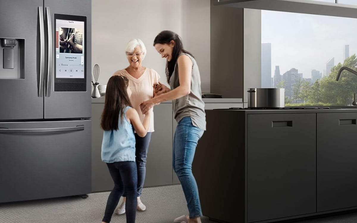 Família na cozinha ao lado de geladeira Samsung French Door com tela Family Hub