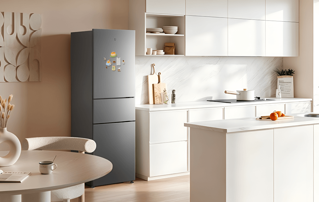Geladeira Xiaomi Mijia 271L cinza, de três portas, ao lado da bancada de uma cozinha clara
