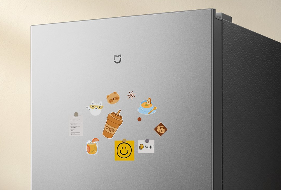 Detalhe da porta superior da geladeira Mijia 271L, em acabamento cinza metálico com logo Mijia e ímãs decorativos