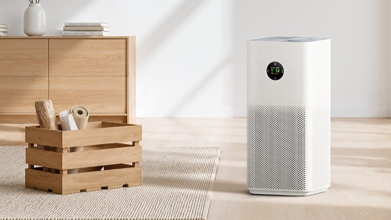 Purificador de ar Xiaomi Mijia 6C, uma torre branca com visor redondo, ao lado de uma cômoda de madeira em uma sala clara