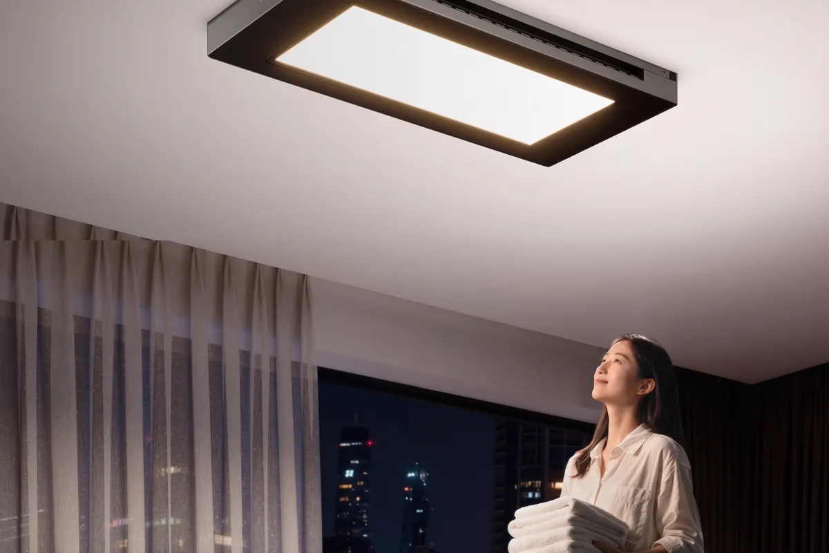 Varal elétrico de teto Mijia Smart Clothes Dryer 3 Max instalado com roupas estendidas e painel de iluminação aceso